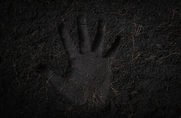 Hand print in black land for plant background, Top view of Handprint on fresh soil with mulch for...