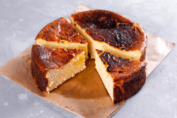 Basque Burnt Cheesecake cut and sliced for serving on a background