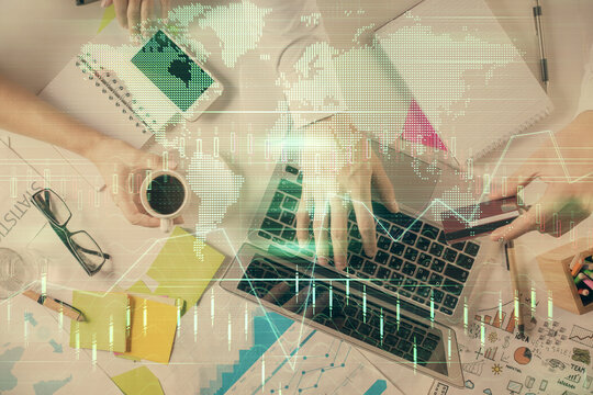 Multi exposure of man's hands typing over computer keyboard and forex graph hologram drawing. Top view. Financial markets concept. © peshkova