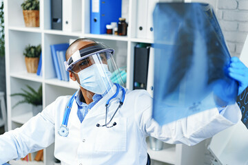 Naklejka premium Male doctor examines an x-ray of lungs in hospital