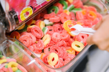 Woman grabbing colorful jelly, colorful background concept.