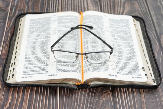 Glasses lie on the bible, close-up, background.