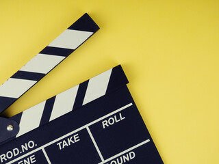Fototapeta na wymiar the concept of the film industry, a minimalistic composition on a yellow background with glasses and clapperboard. movies and cinema.