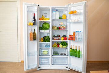 Open fridge full of fruits, vegetables and drinks