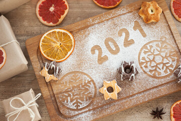 Christmas and New Year 2021 background with ingredients for cooking christmas baking decorated with fir tree. New Year's decor, homemade cookies preparing for the holiday.