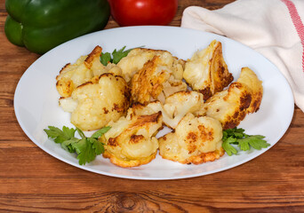 Cauliflower fried in batter on dish on the rustic table