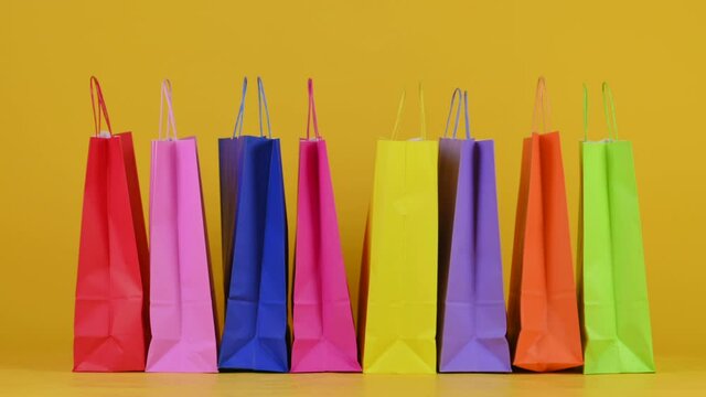 background of shopping bags on a yellow studio bashound. Shopping concept	