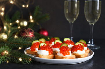 Toasts with cheese and red caviar on a New Year's table with champagne. New Year's table. Snack.