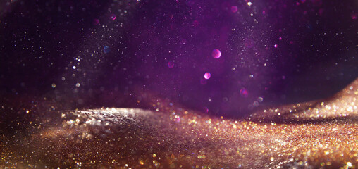 background of abstract glitter lights. Gold ,purple and black. de focused