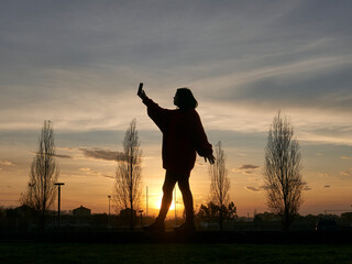 Fototapeta na wymiar silhouette girl talking on smartphone outdoors