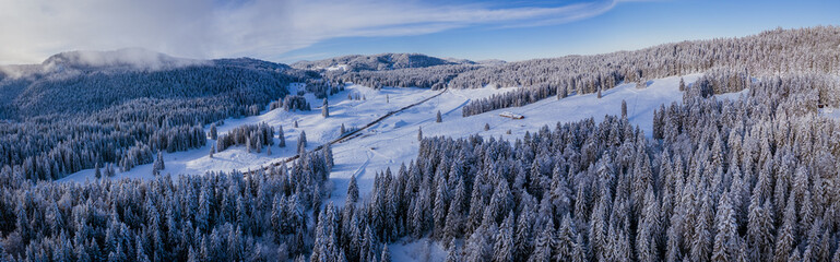 Stunning winter scene landscape of snow covered trees and forest as a road cuts through the landscape.