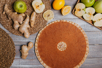 Lime and ginger fruit leather with fresh fruits on the wooden table. Round fruit leather. Healthy food. Apples, bananas, lime, ginger top view.