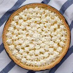 Homemade Tasty Banana Cream Pie on a white wooden table, top view. Flat lay, overhead, from above.
