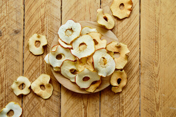 Slices of Dried apples on wooden background. fruit snack or ingredient for baking, cooking. Homemade Dried dehydrated apple chips