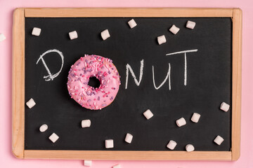 The inscription "DONUT" on a black slate painted marshmallow