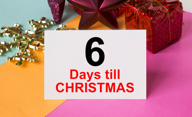 Christmas tree decorated with toys and tinsel, gift boxes and greeting card with text 6 Days till...