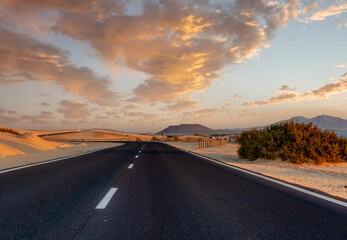 Fototapeta na wymiar scenic road that runs through the sand dunes of Fuerteventura