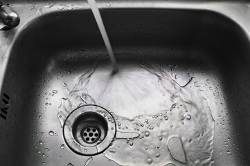 a wet dirty sink after washing many dishes photo may had noise and gain