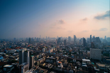 Cityscape photo show traffic jams on the highway of a big city in evening cover by dust mist that made two color sky