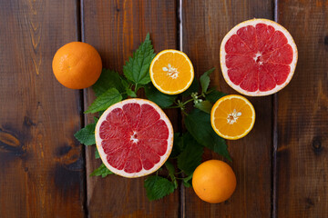 oranges and grapefruit on a brown wooden background, top view, text space, citrus