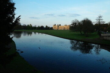 Fototapeta premium River Cam and an Audley End House in Saffron Walden. Water reflection. View from the road.