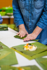 Obraz na płótnie Canvas Wrapping tamales Latin American dish.