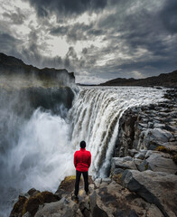 Hiker standing close to the Dettifoss waterfall in Iceland