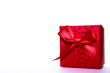Red gift box with red ribbon bow and empty white wall background abstract