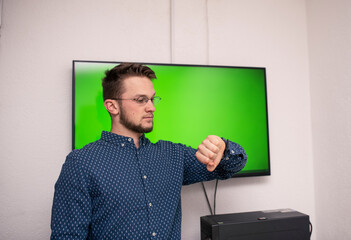 young caucasian businessman wearing glasses presents his presentation on a smart board with a smart pen.european businessman at office presentation. Businessman watching on wristwatch.