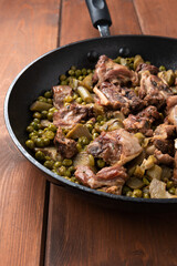 Stufato di carne di agnello con pisellini e carciofi 