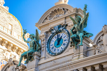 Monte-Carlo, Monaco 29.11.2020 Clock With Bronze Sculptures Of Angels Above The Main Entrance Of Monte-Carlo Casino In Monaco, Europe. High quality photo