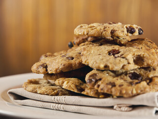 Chocolate cookies on linen napkin on wooden table with blurred background