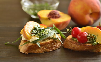 Crostini with grilled peaches, tomatoes, cream cheese and pesto