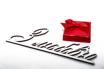 Red gift mini-box with a red bow on a white background and text with love in Ukrainian in front. Close-up. Greeting card