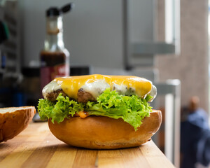 Guy making hamburger or cheeseburger. Enjoying a tasty good looking hamburger. Satisfying hunger and feeling fulfilled.