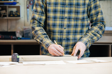 A wood craftsman makes a product for a private order, a professional employee makes measurements for working with a wooden product