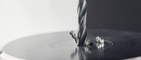 metal drill bit make holes in steel billet with lubricating liquid on industrial drilling machine....