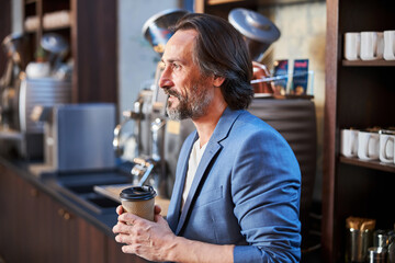 Attractive gentleman having coffee at hotel bar