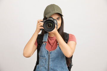 Female photographer taking picture with digital camera on white.