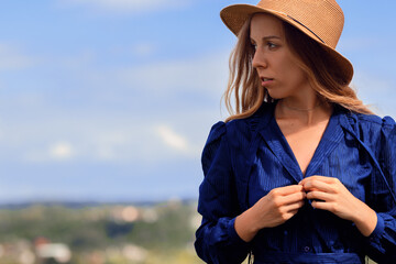 Girl in a blue dress walks in the field