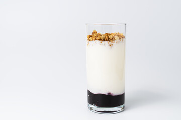 Healthy layered dessert with bio yogurt, granola and balckcurrant jam on white background.