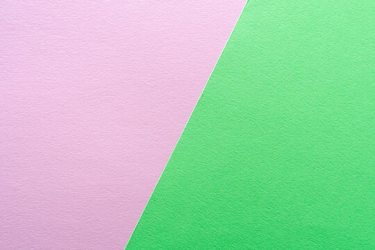 Paper texture background of pastel green and pink colors. Sheets of blank light green and pink paper with fine texture devided  by a sloping border.