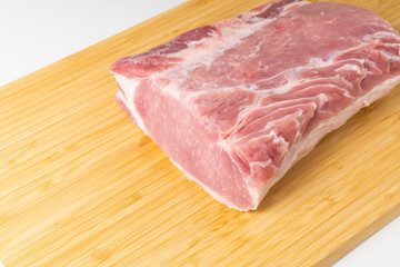 Piece of raw boneless pork loin on cutting board.