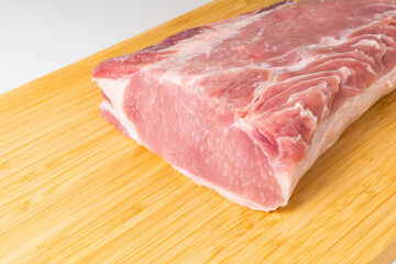 Raw boneless pork loin or pork chop on cutting board.