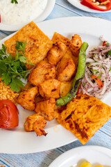 chicken shish kebab in a plate with appetizers. top wiev