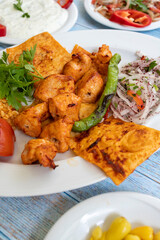 chicken shish kebab in a plate with appetizers