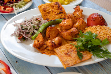 chicken shish kebab in a plate with appetizers