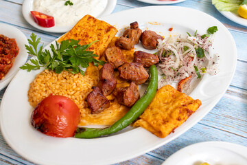 meat shish kebab in a plate with appetizers