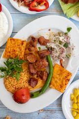 meat shish kebab in a plate with appetizers. top wiev