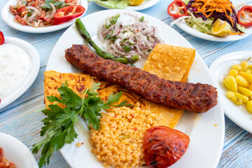 in the plate with the hot kebab and appetizers. adana kebab